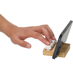 A bamboo stand keyboard stress reliever with a white keyboard and a smartphone on a wooden base.