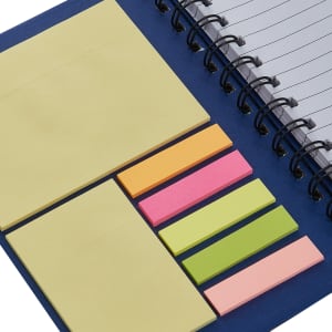 A dark blue notebook with spiral binding, featuring assorted sticky notes in yellow, pink, green, and orange.