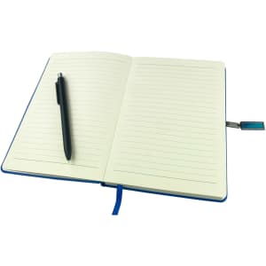 A blue notebook with lined pages, accompanied by a black pen and a small USB attachment.