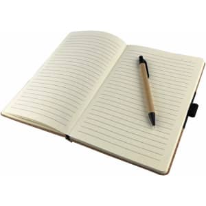 An open notebook with lined pages and a black pen resting on the right side. The cover is brown and features a branding logo.