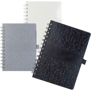 A collection of La Trobe Stone Paper Notebooks in white, grey, and black, featuring textured covers and spiral bindings.