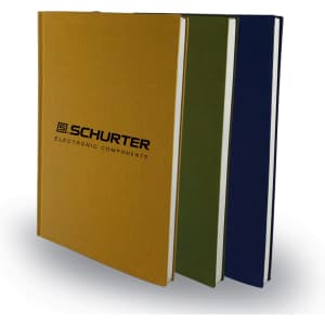 Three notebooks in gold, green, and navy blue, featuring a logo on the cover.