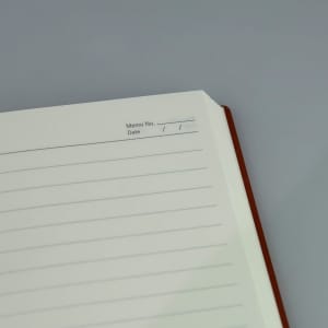 A brown A5 notebook with lined pages and a space for memo number and date at the top.