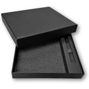 A black gift box containing a notebook and pen, lined with foam for protection.