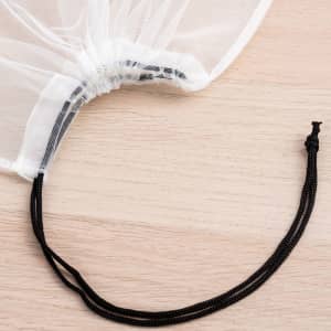 A white nylon mesh produce bag with a gathered top and a black drawstring for closure.