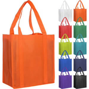 An orange non-woven shopping bag with two handles, displayed alongside a variety of other coloured bags.