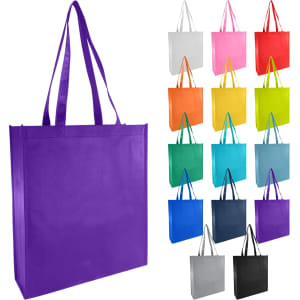 A large purple non-woven bag with long handles, surrounded by bags in various colours including pink, orange, and blue.