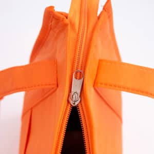 An orange non-woven cooler bag featuring a top zip closure and two sturdy handles. It has a branding logo.