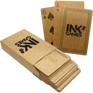 A set of eco-friendly recycled playing cards in a brown cardboard box, featuring an Ace and a Six of Spades.
