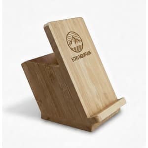 A bamboo mobile stand and pen holder with an angled design and a logo on the front.