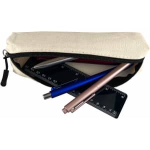 A cream canvas tube pencil case with blue, silver, and rose gold pens and a ruler inside.
