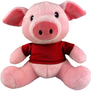 A pink pig plush toy wearing a red shirt, with large ears and a smiling face. It has a logo on the shirt.