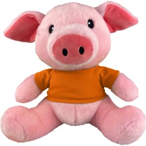 A pink plush pig toy wearing an orange shirt, featuring a smiling face and large ears. It has a logo on its shirt.