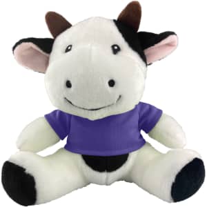 A plush cow toy featuring a black and white design, wearing a purple shirt and a friendly expression.