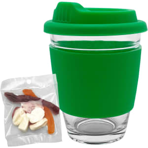 A green reusable coffee cup with a silicone sleeve beside a bag of assorted jelly candies.