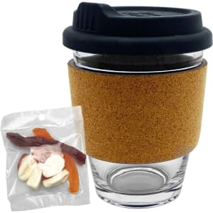 A glass coffee cup with a cork band, accompanied by a mixed bag of colourful jelly lollies.