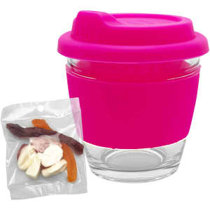 A pink Venice glass coffee cup with a silicone lid, alongside a packet of mixed lollies.