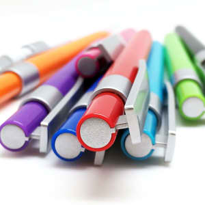 A collection of plastic pens in various colours including purple, orange, red, blue, teal, and green, featuring silver accents.