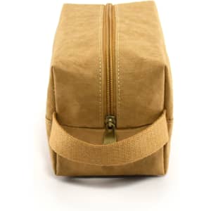 A tan kraft paper cosmetic bag with a zip closure and a side handle. It features a simple design and minimal branding.