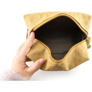 A kraft paper cosmetic bag in a light brown hue, featuring an unzipped opening with a fabric interior.