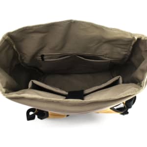 An open beige laptop backpack with compartments and pockets inside. It features a logo on the exterior.