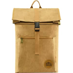 A brown kraft paper laptop backpack with a fold-over top, zippered front pocket, and a logo patch.