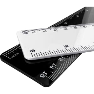 Two plastic rulers, one white and one black, overlapping with measurement markings in both centimetres and inches.