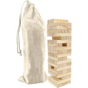 A Small Jenga set featuring wooden blocks stacked beside a cream drawstring bag.