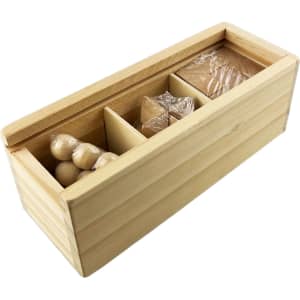 A wooden box containing various puzzle pieces, including spheres and shapes, in a natural wood finish.