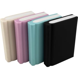 Four book-shaped rubber erasers in cream, pink, teal, and black, featuring rounded edges and varying thicknesses.