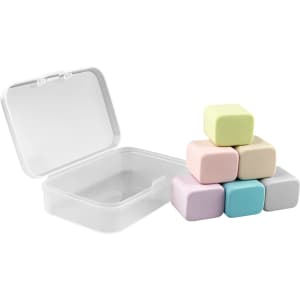 A set of six pastel-coloured rubber erasers stacked beside a clear storage box.