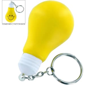 A yellow light bulb key ring with a smiley face on the back and a metal keychain.