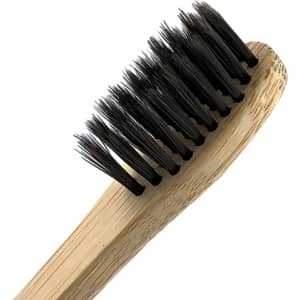 A bamboo toothbrush with a light brown handle and black bristles, featuring a simple design and natural materials.
