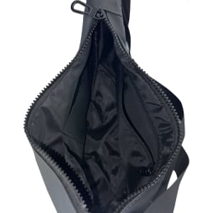 An open black satchel bag with a smooth interior lining and a zippered pocket. It features a zippered closure and has a logo.