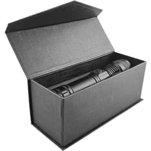 A black outdoor torch placed inside an open black box. The packaging has a textured finish.
