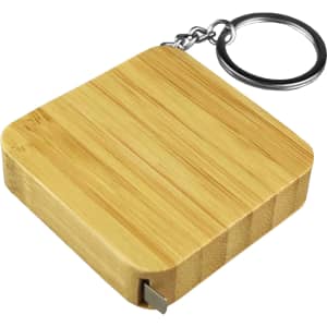 A bamboo tape measure key ring with a square design and a metal key ring attachment.