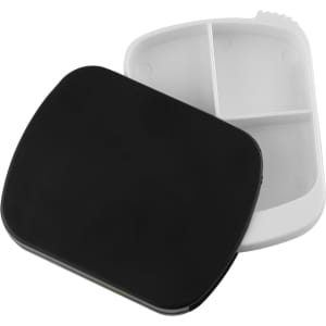 A black spin pill box with a white interior, featuring compartments for organising medication. It has a logo on the exterior.