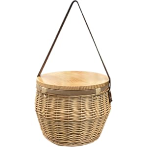 A round wicker picnic cooler basket with a wooden lid and a shoulder strap, showcasing natural tones.