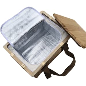 A square wicker picnic cooler basket in natural wood with a beige lid and an insulated silver interior.