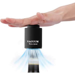 A wine stopper in black with a hand placed on top, designed to create a vacuum seal for bottles.