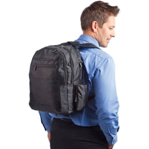 A black laptop backpack with multiple compartments is worn by a man in a blue shirt. The bag features a logo.