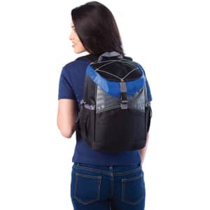 A backpack cooler in black and blue, featuring a logo, worn by a woman from the back.
