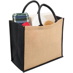 A jute tote bag with wide gusset, featuring black sides and a natural beige centre, filled with a blanket and other items.