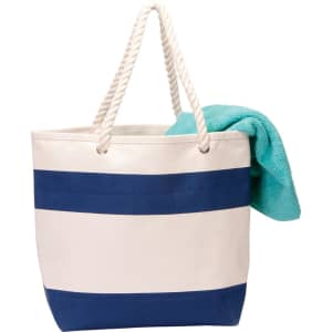 A striped cotton canvas tote bag in cream and navy blue, featuring twisted rope handles and a turquoise towel.