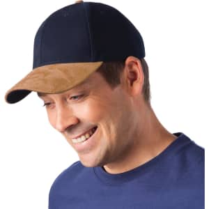 A navy and tan sueded peak cap is worn by a smiling man, featuring a logo on the front.
