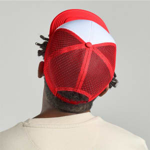 A red and white trucker cap featuring a mesh back and a logo at the rear.