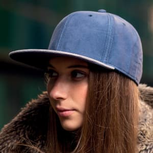 A blue cap worn by a person with long hair, featuring a flat brim and a logo on the front.