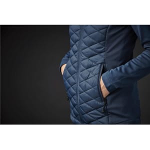 A navy blue women's thermal shell jacket featuring a quilted pattern and side pockets. Includes a subtle logo.
