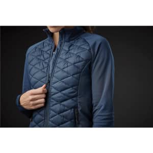A women's thermal shell jacket in navy blue featuring a quilted design and side pockets. Includes a logo.
