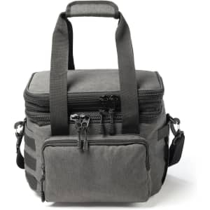 A grey expanding cooler with dual handles, zippers, and a front pocket, featuring adjustable straps and a logo.